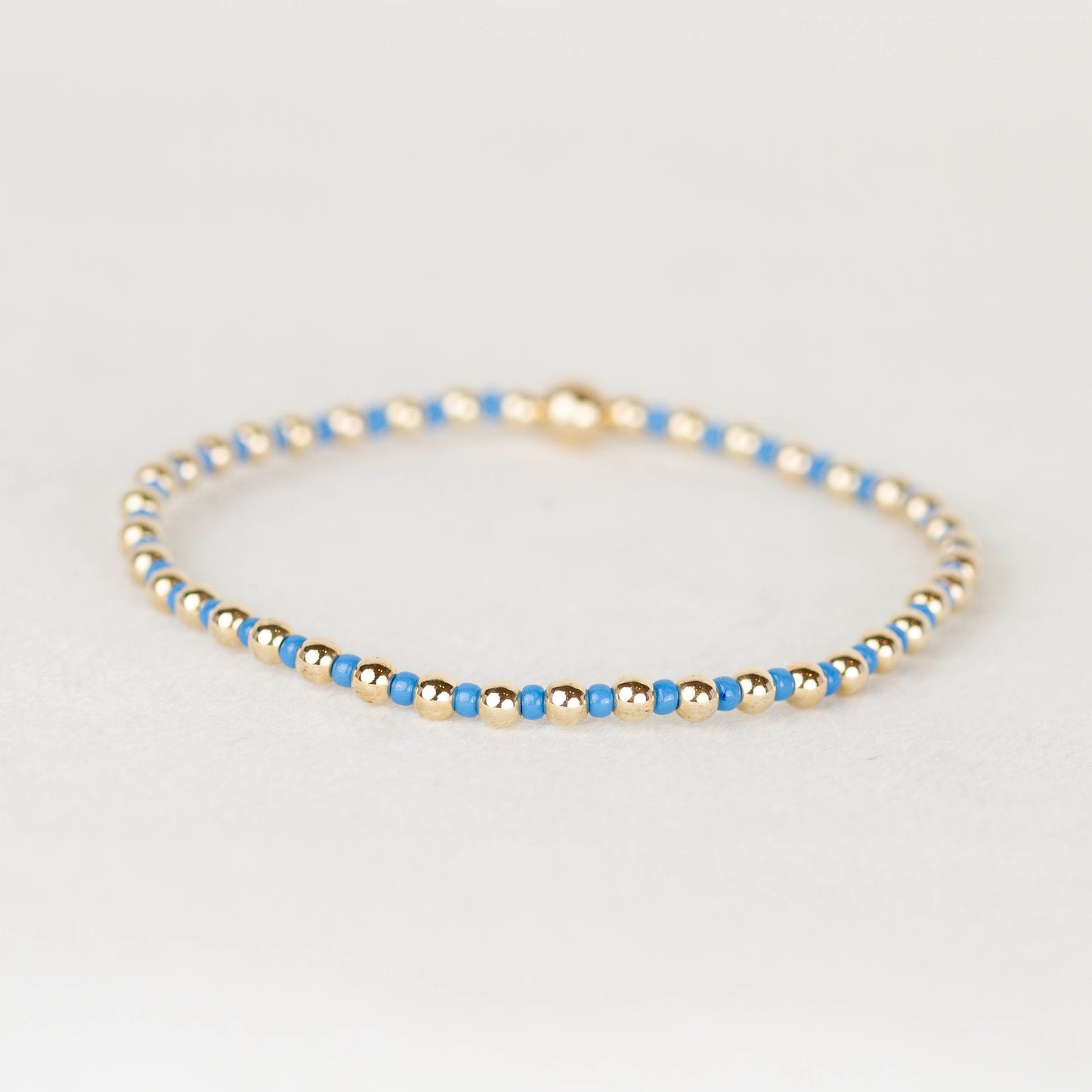 Blue Bella seed bead alternating with 14k gold filled or sterling silver beaded stretch bracelet 

