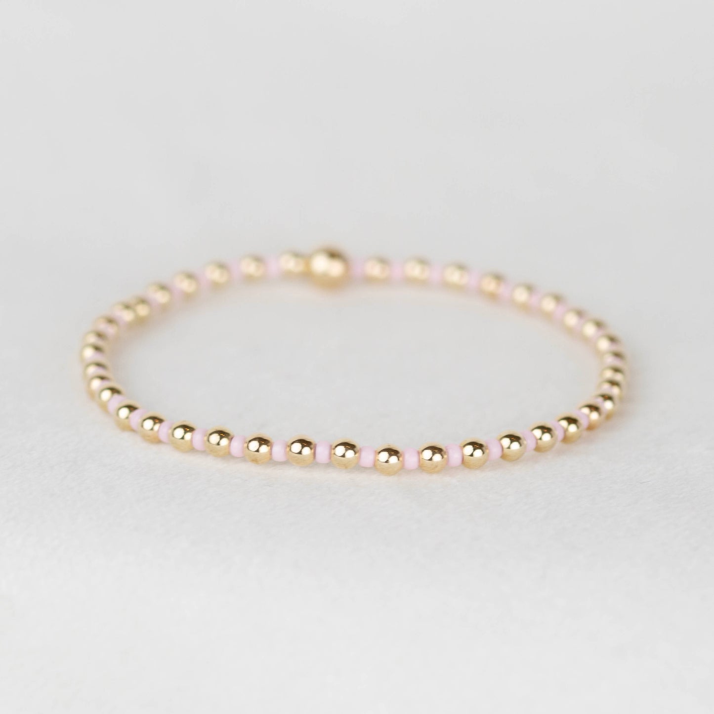 Light pale pink Bella seed bead alternating with 14k gold filled or sterling silver beaded stretch bracelet 
