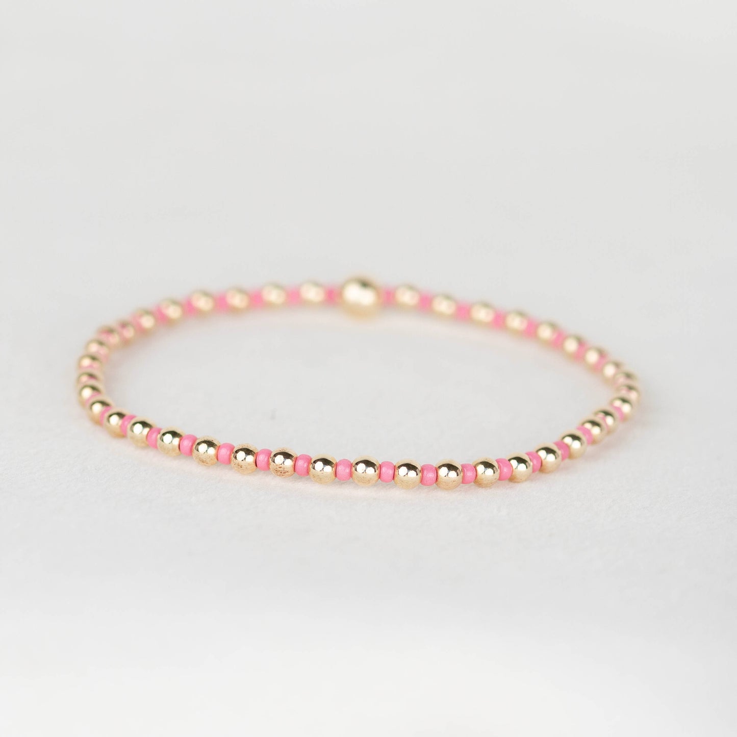 Bubblegum pink Bella seed bead alternating with 14k gold filled or sterling silver beaded stretch bracelet 
