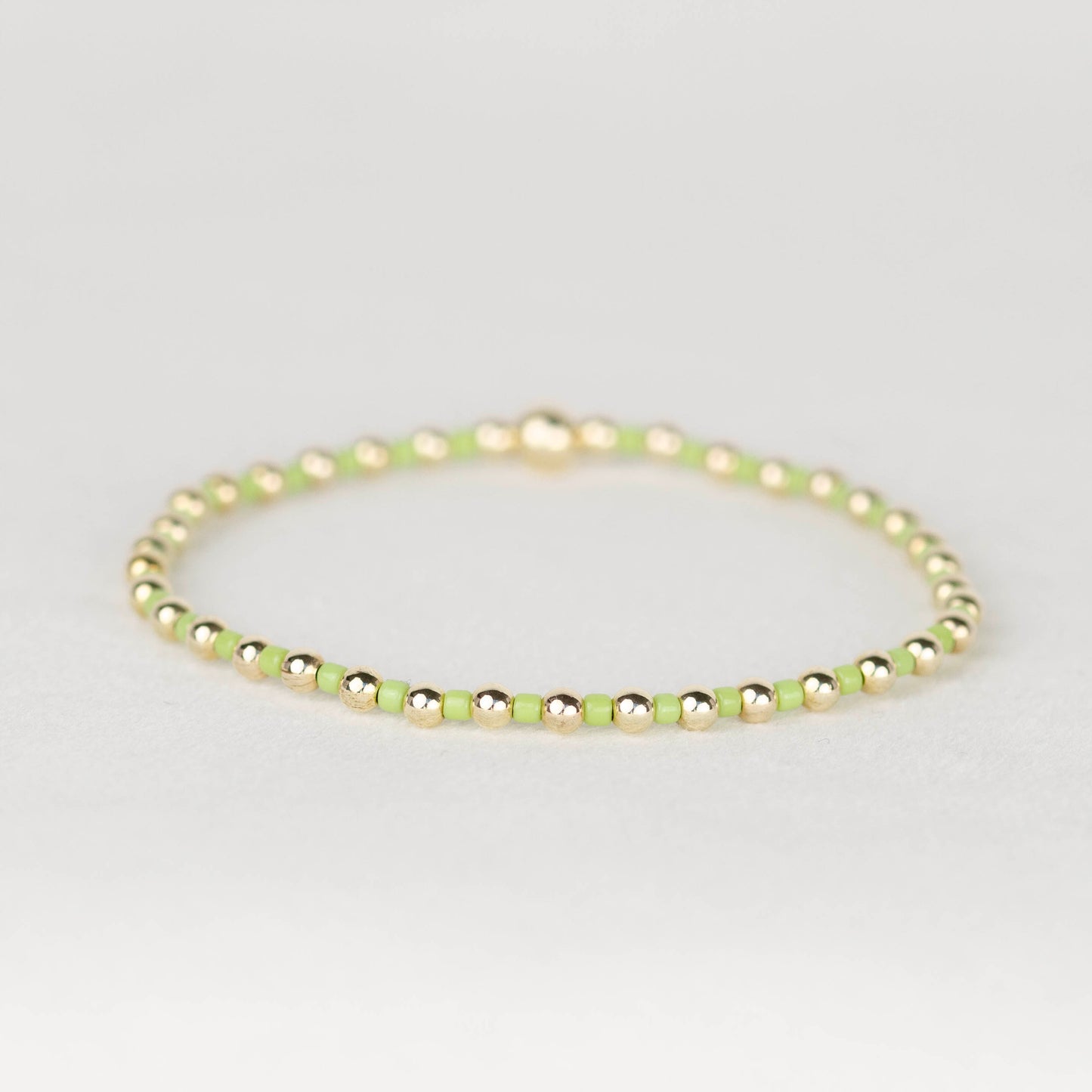 Chartreuse green Bella seed bead alternating with 14k gold filled or sterling silver beaded stretch bracelet 
