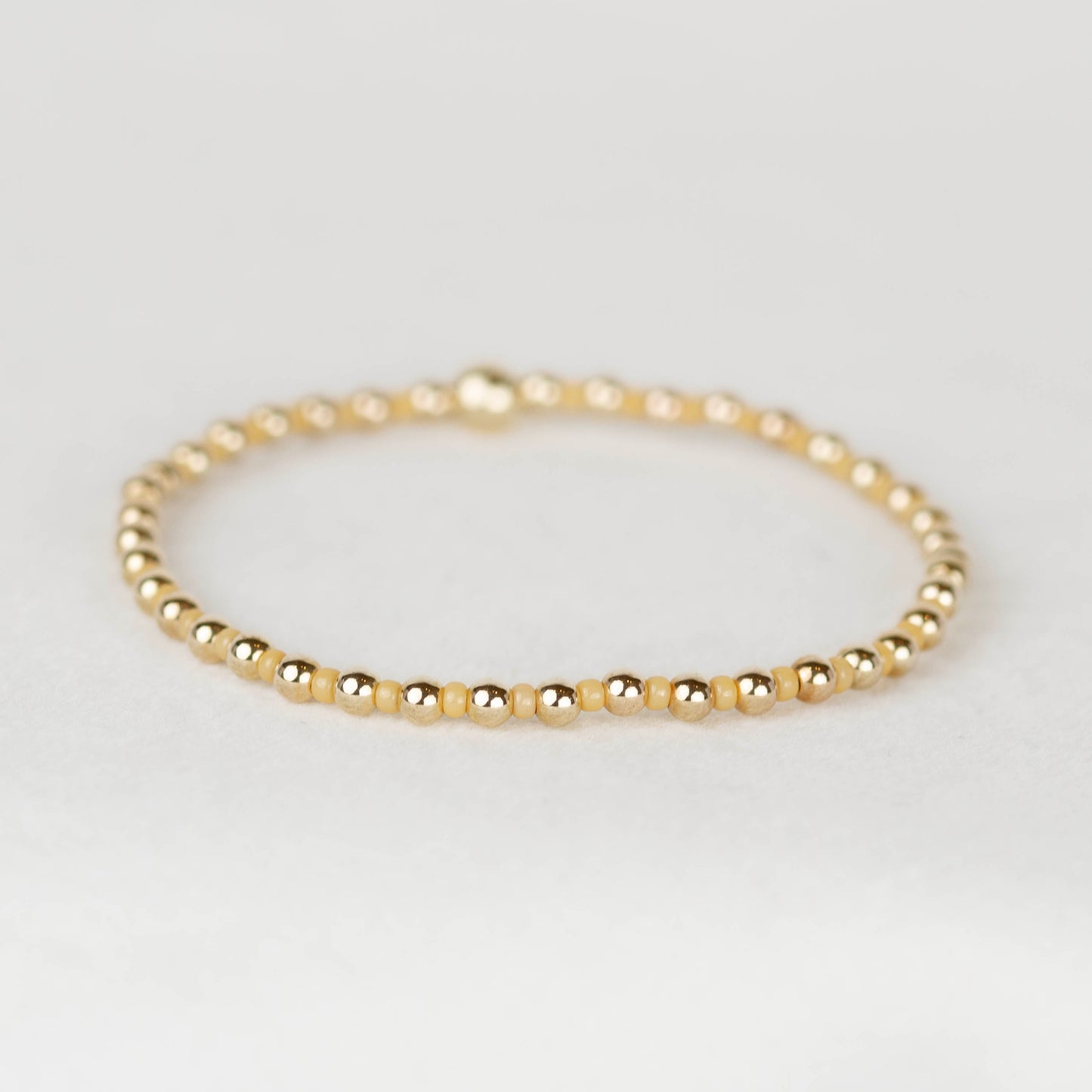 Golden yellow Bella seed bead alternating with 14k gold filled or sterling silver beaded stretch bracelet 

