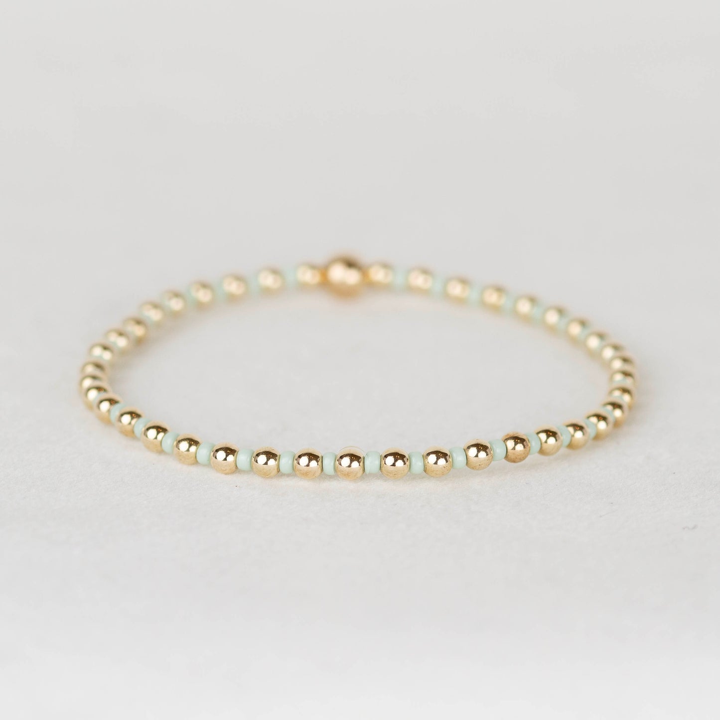 Mint green Bella seed bead alternating with 14k gold filled or sterling silver beaded stretch bracelet 
