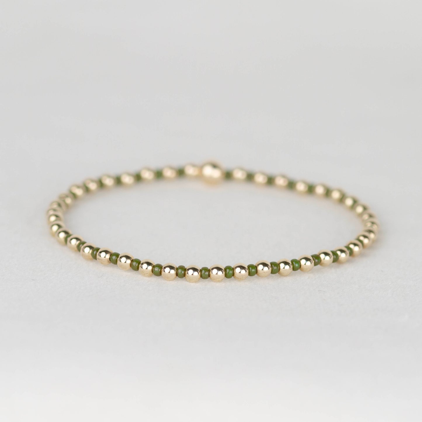 Moss army green Bella seed bead alternating with 14k gold filled or sterling silver beaded stretch bracelet 
