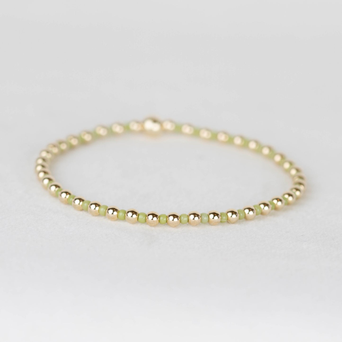 Olive green Bella seed bead alternating with 14k gold filled or sterling silver beaded stretch bracelet 
