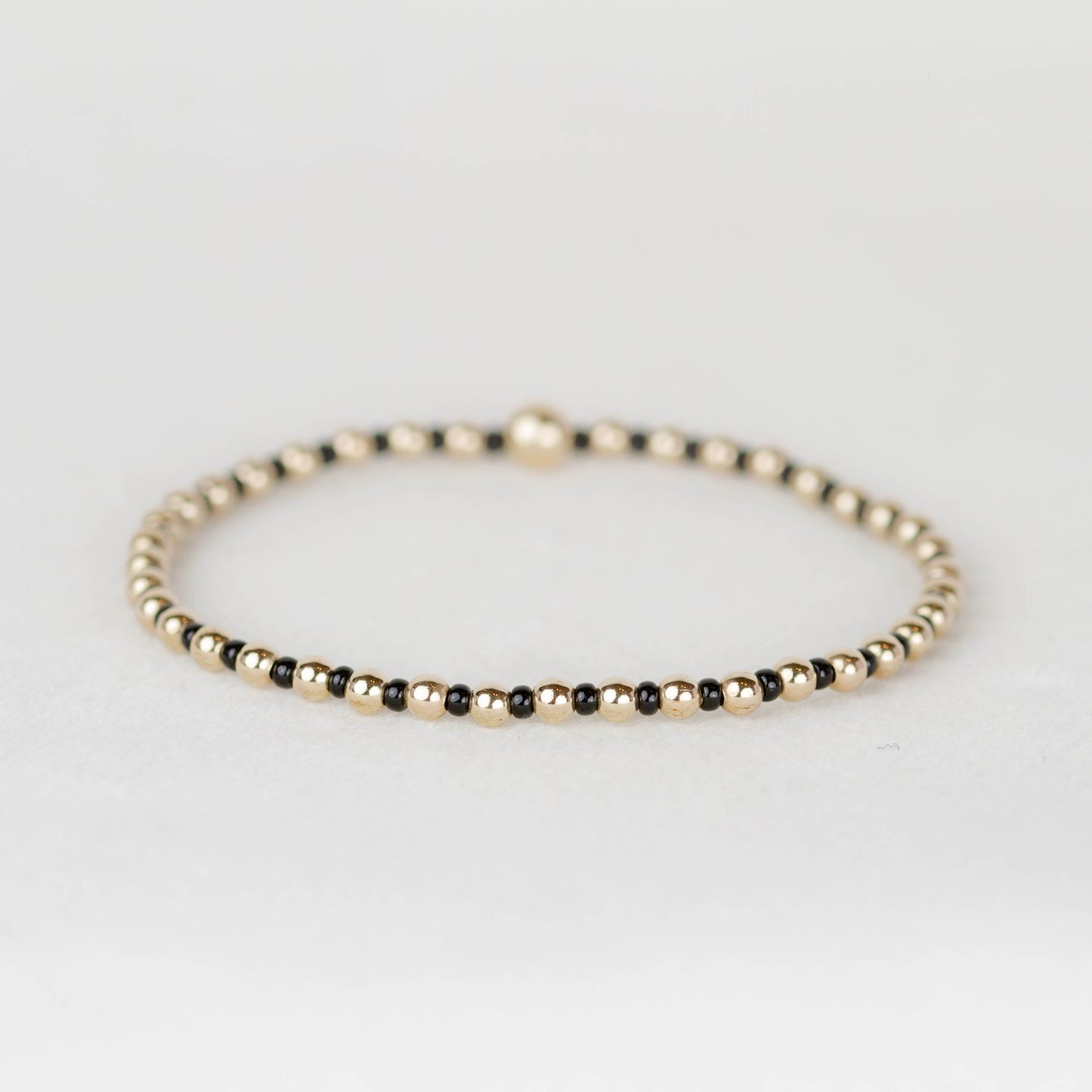 Black Bella seed bead alternating with 14k gold filled or sterling silver beaded stretch bracelet 
