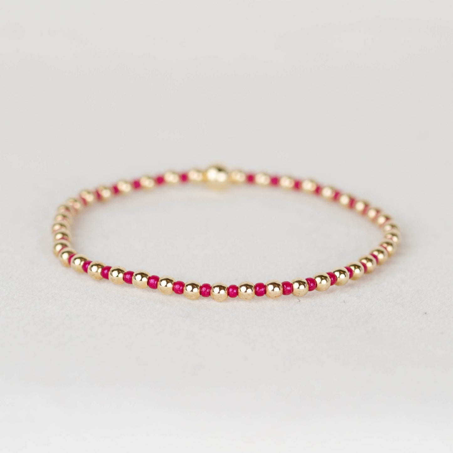 Bold pink Bella seed bead alternating with 14k gold filled or sterling silver beaded stretch bracelet 
