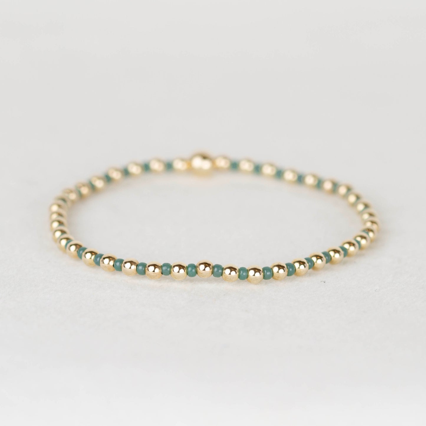 Wintergreen Bella seed bead alternating with 14k gold filled or sterling silver beaded stretch bracelet 
