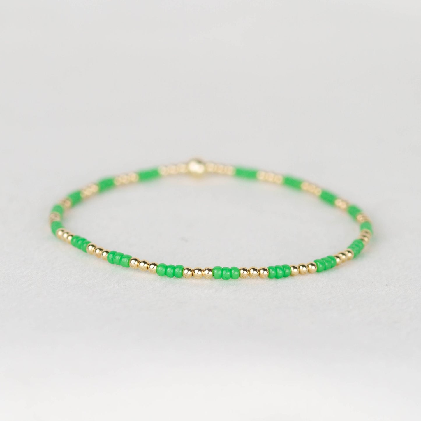 Bright green Madi seed bead alternating with 14k gold filled or sterling silver beaded stretch bracelet 