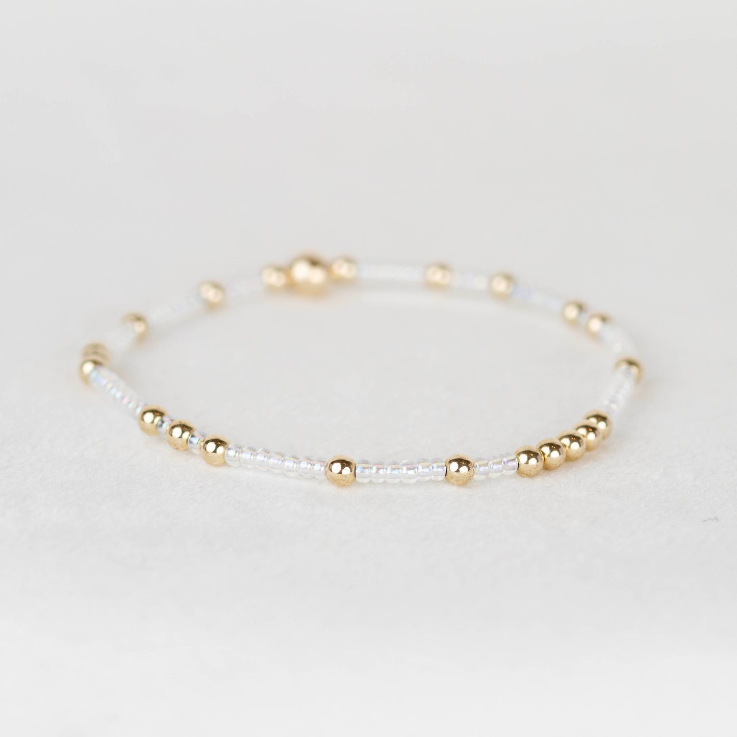 Clear Irredescent Olivia seed bead with scattered 14k gold filled or sterling silver beaded stretch bracelet 
