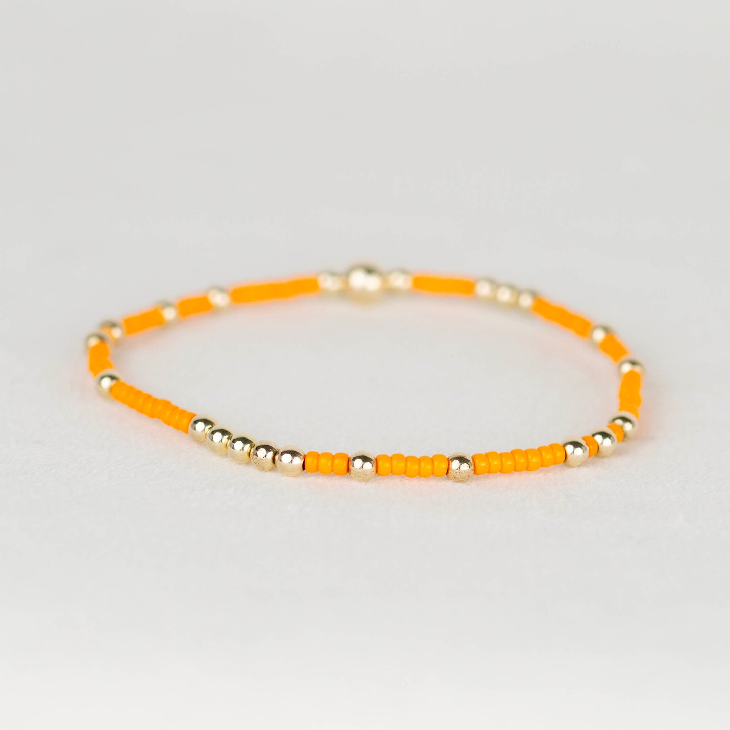 Orange Olivia seed bead with scattered 14k gold filled or sterling silver beaded stretch bracelet 