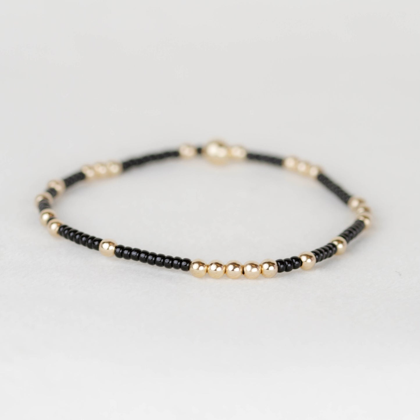 Black Olivia seed bead with scattered 14k gold filled or sterling silver beaded stretch bracelet 
