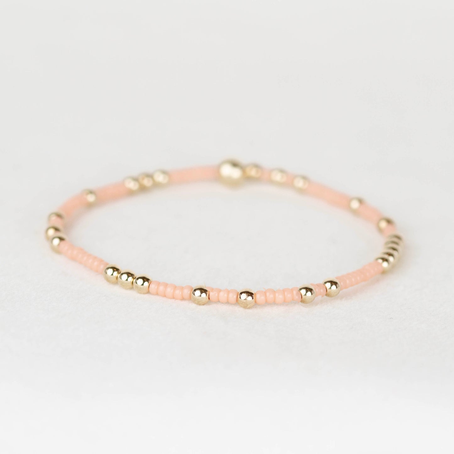 Peach A red pop of color. Olivia pairs delicate 2mm seed beads with scattered 3mm gold-filled or sterling silver beads for an effortless everyday stack.