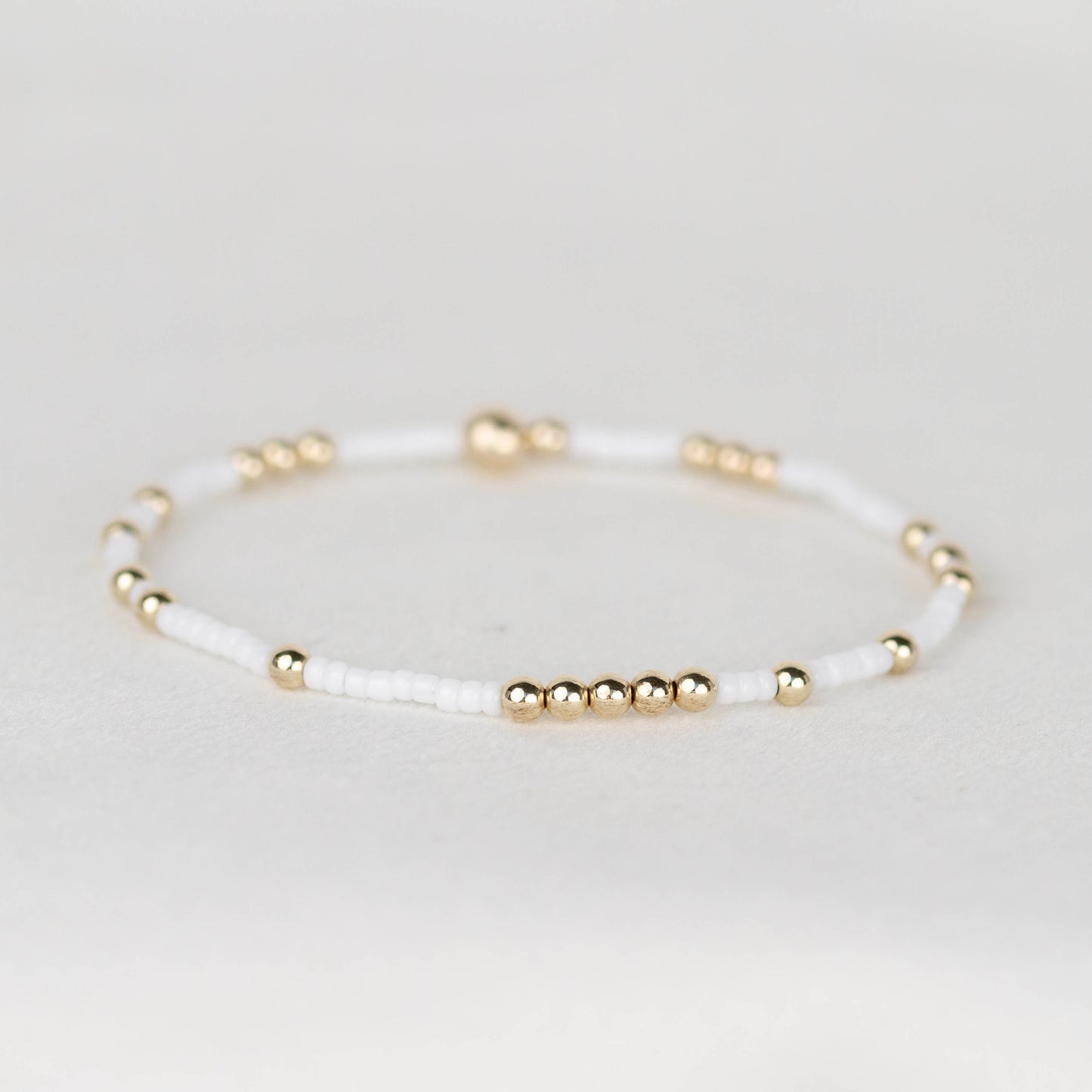 White Olivia seed bead with scattered 14k gold filled or sterling silver beaded stretch bracelet 
