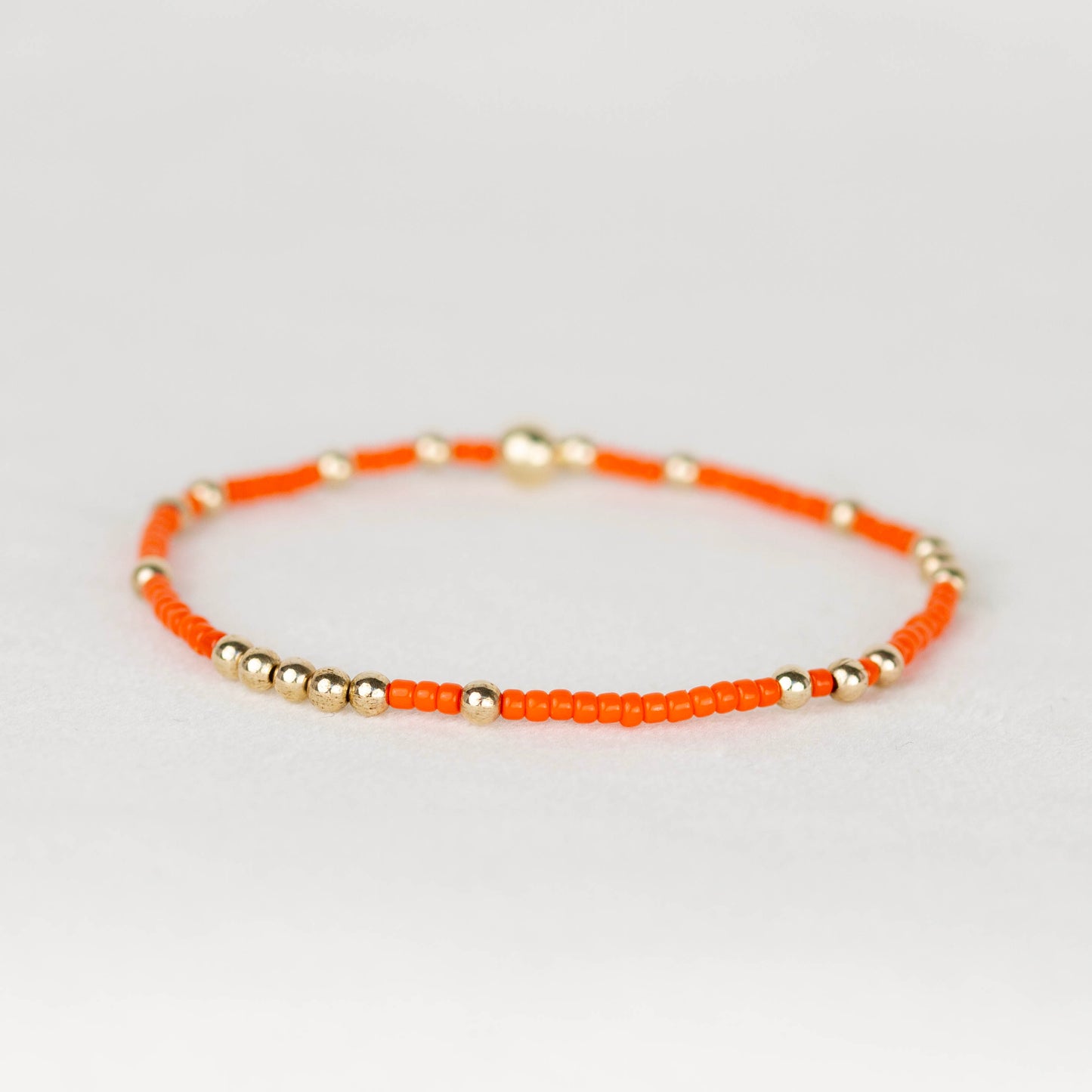 Dark orange Olivia seed bead with scattered 14k gold filled or sterling silver beaded stretch bracelet 